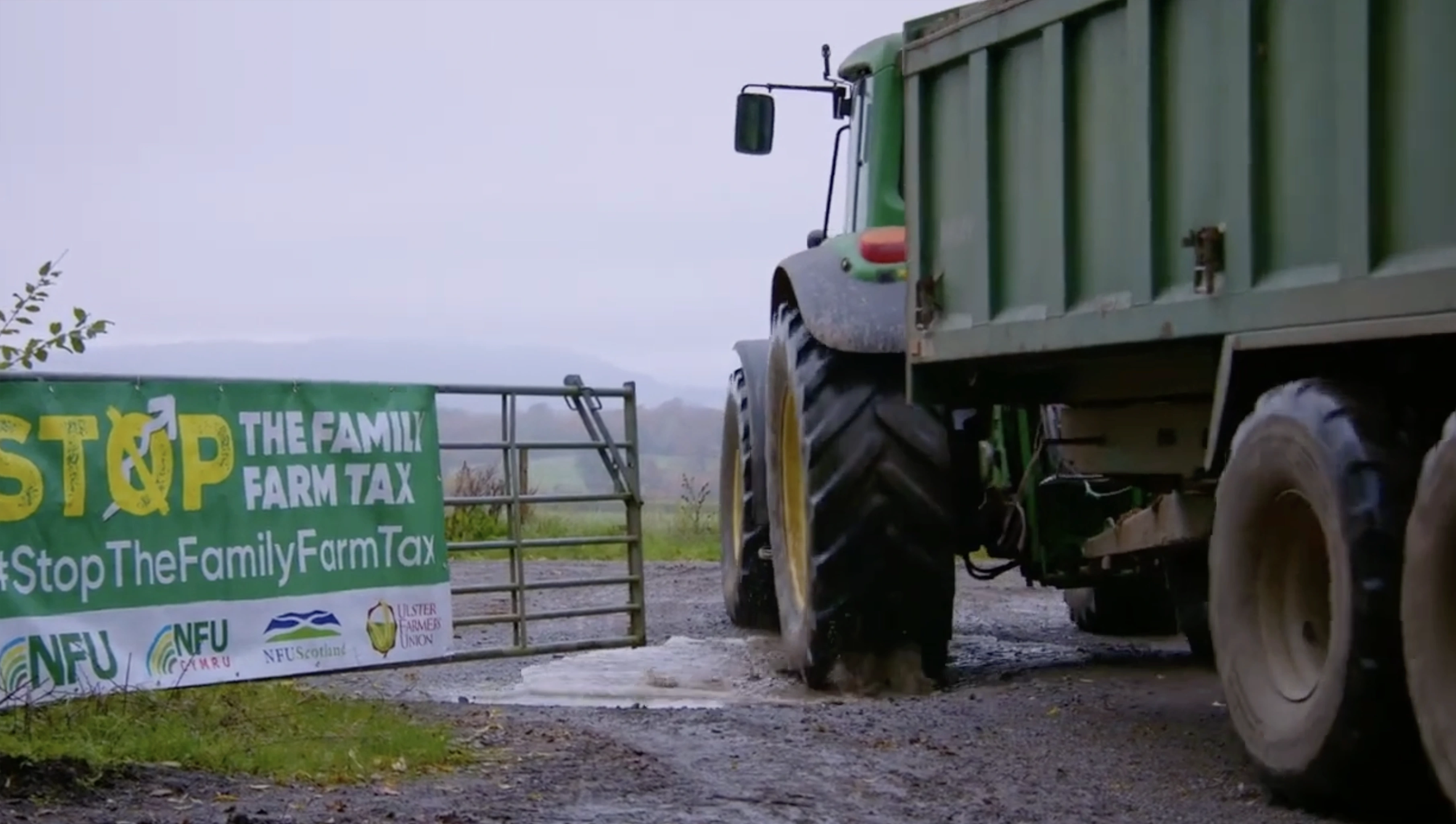 tractor driving through gate with sign